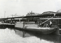 170961 Afbeelding van de overslag van hout van schip naar trein in de haven bij het N.S.-station Zaandam.